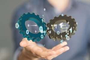 A 3D rendering of digital gears floating over a hand-business gear to success concept