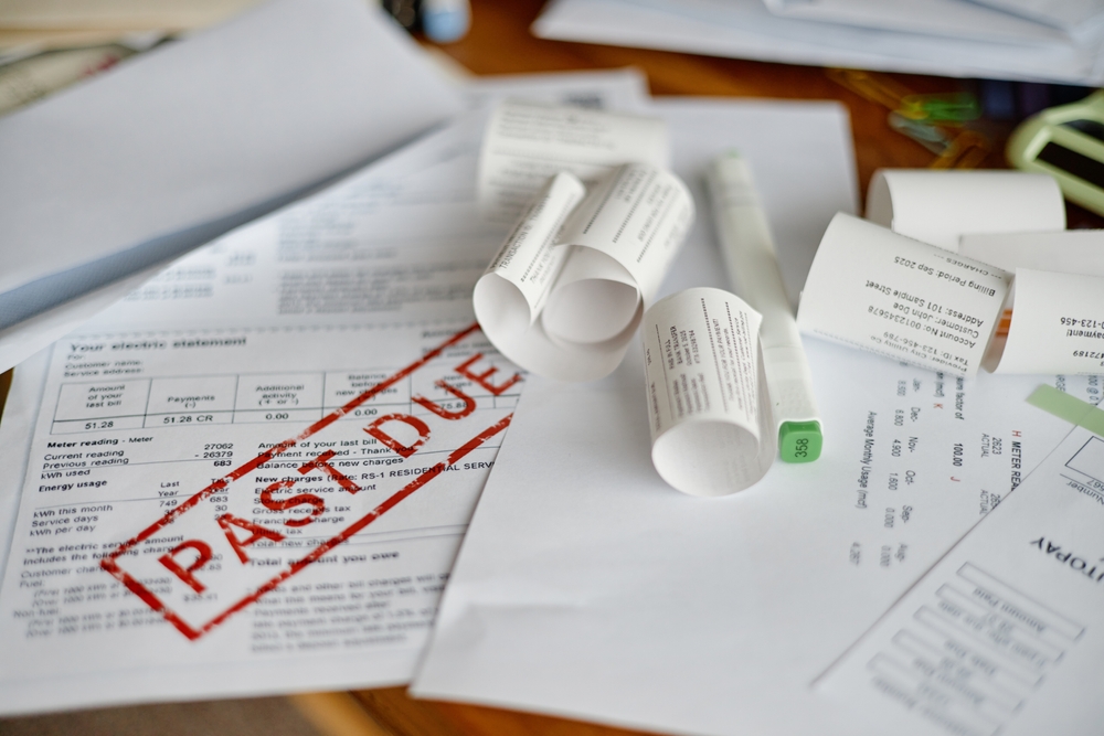 Closeup showing multiple utility bills and invoices scattered on desk